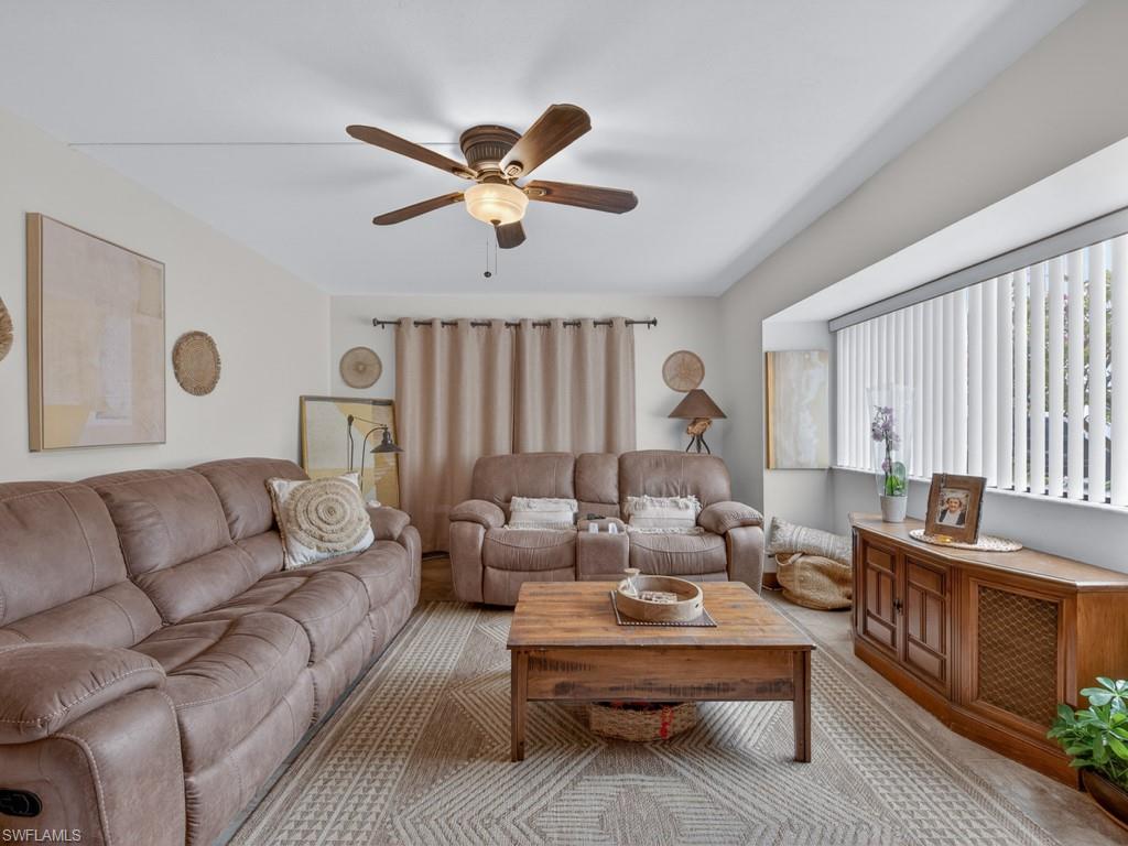 910 Vanderbilt Beach Road, Unit 317W Naples, FL 34108 - Photo 3 of 14 a living room with furniture and a large window