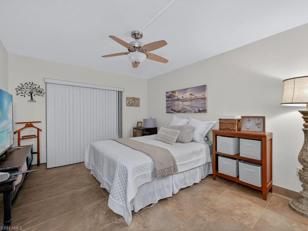 910 Vanderbilt Beach Road, Unit 317W Naples, FL 34108 - Photo 10 of 14 a bedroom with a bed a dresser and a window