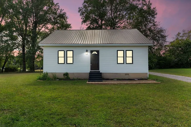 a front view of a house with a garden