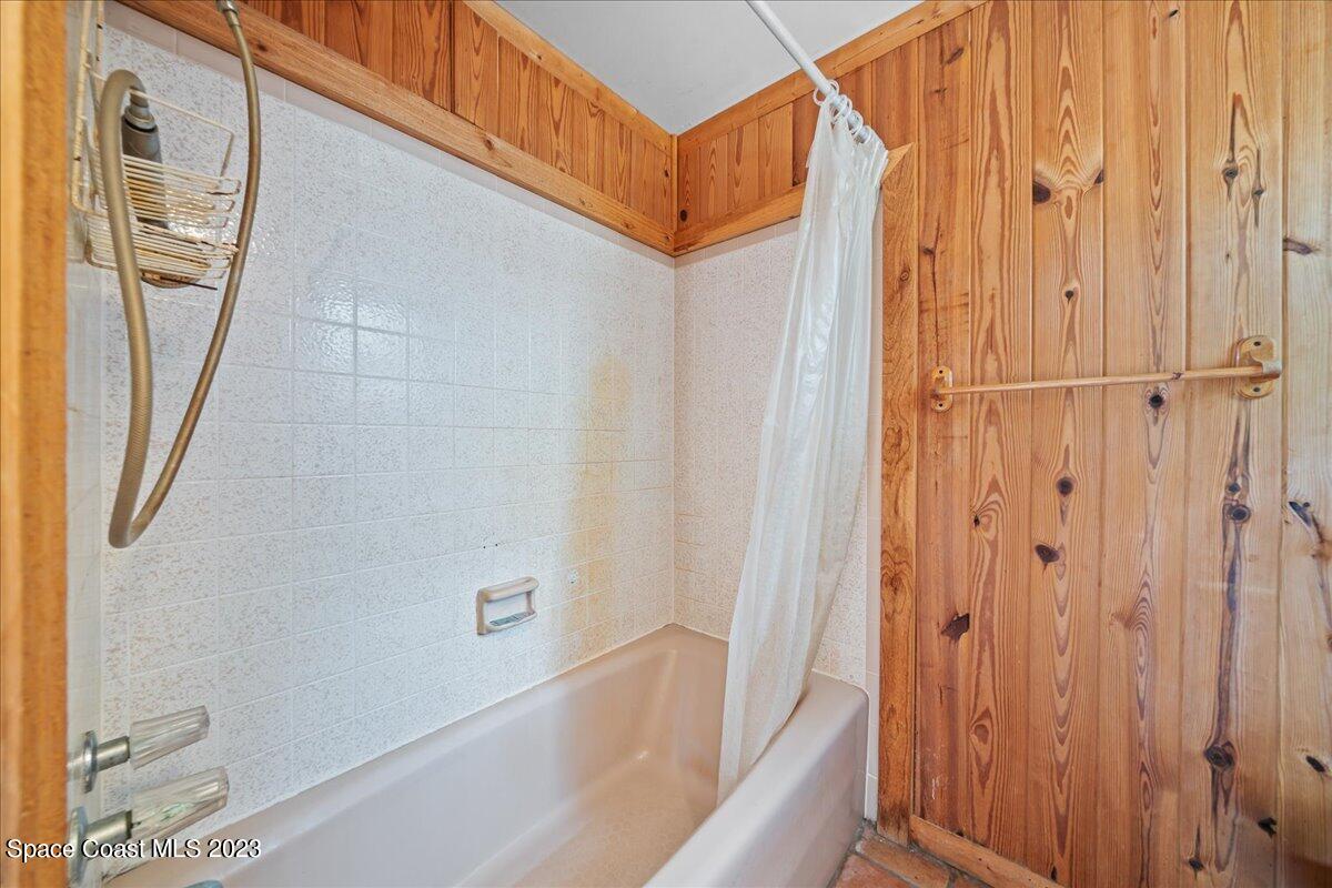 4885 Sand Point Road Grant, FL 32949 - Photo 18 of 36 a bathroom with a bathtub and a shower