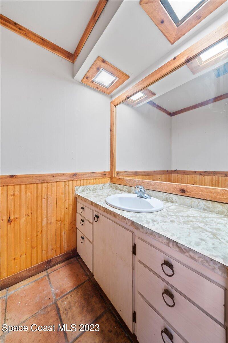 4885 Sand Point Road Grant, FL 32949 - Photo 22 of 36 a bathroom with a granite countertop sink and a mirror