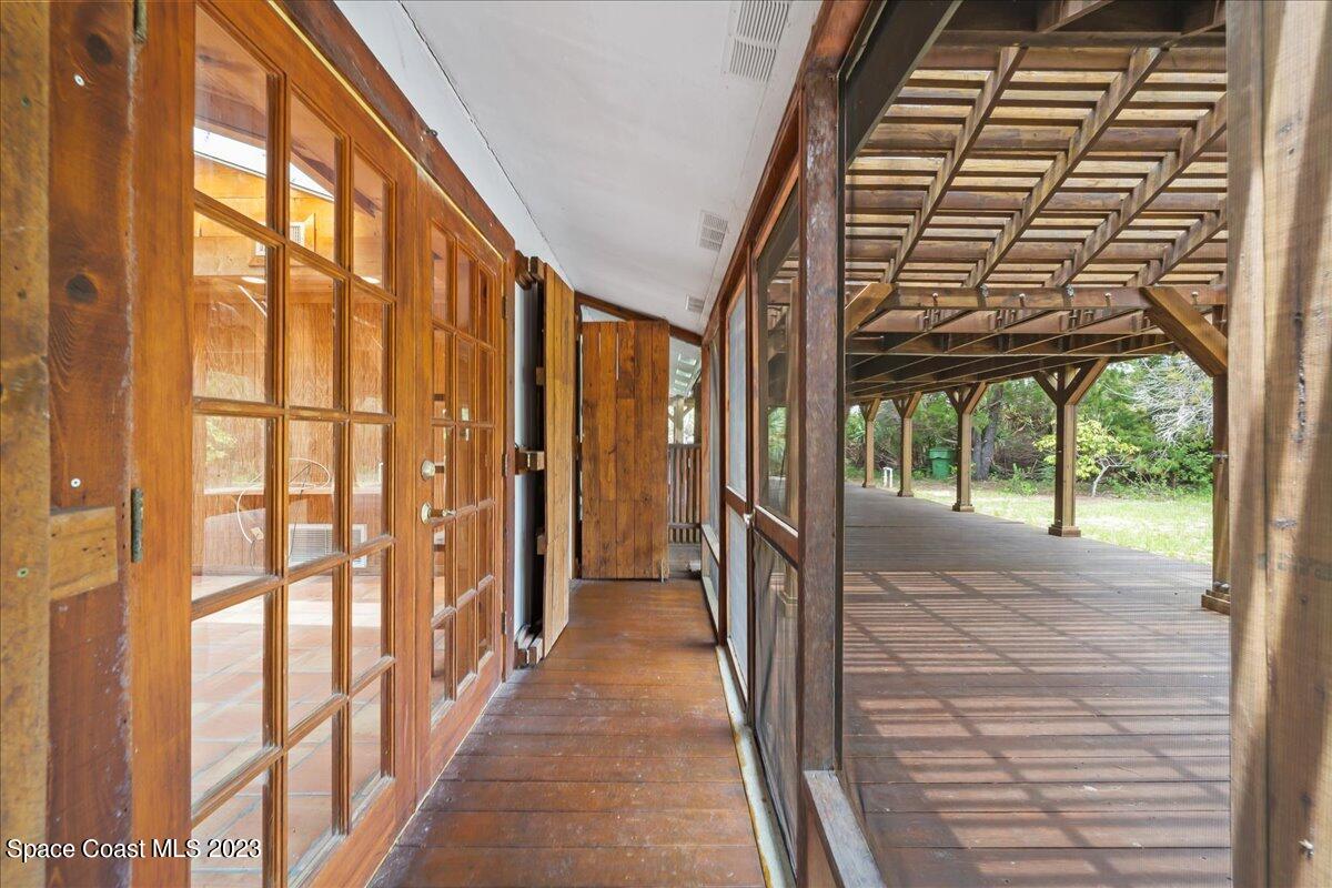 4885 Sand Point Road Grant, FL 32949 - Photo 26 of 36 a view of a porch with a door and wooden floor