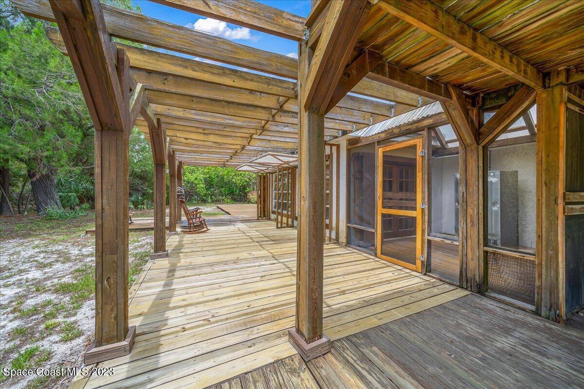 4885 Sand Point Road Grant, FL 32949 - Photo 9 of 36 a porch with wooden floor