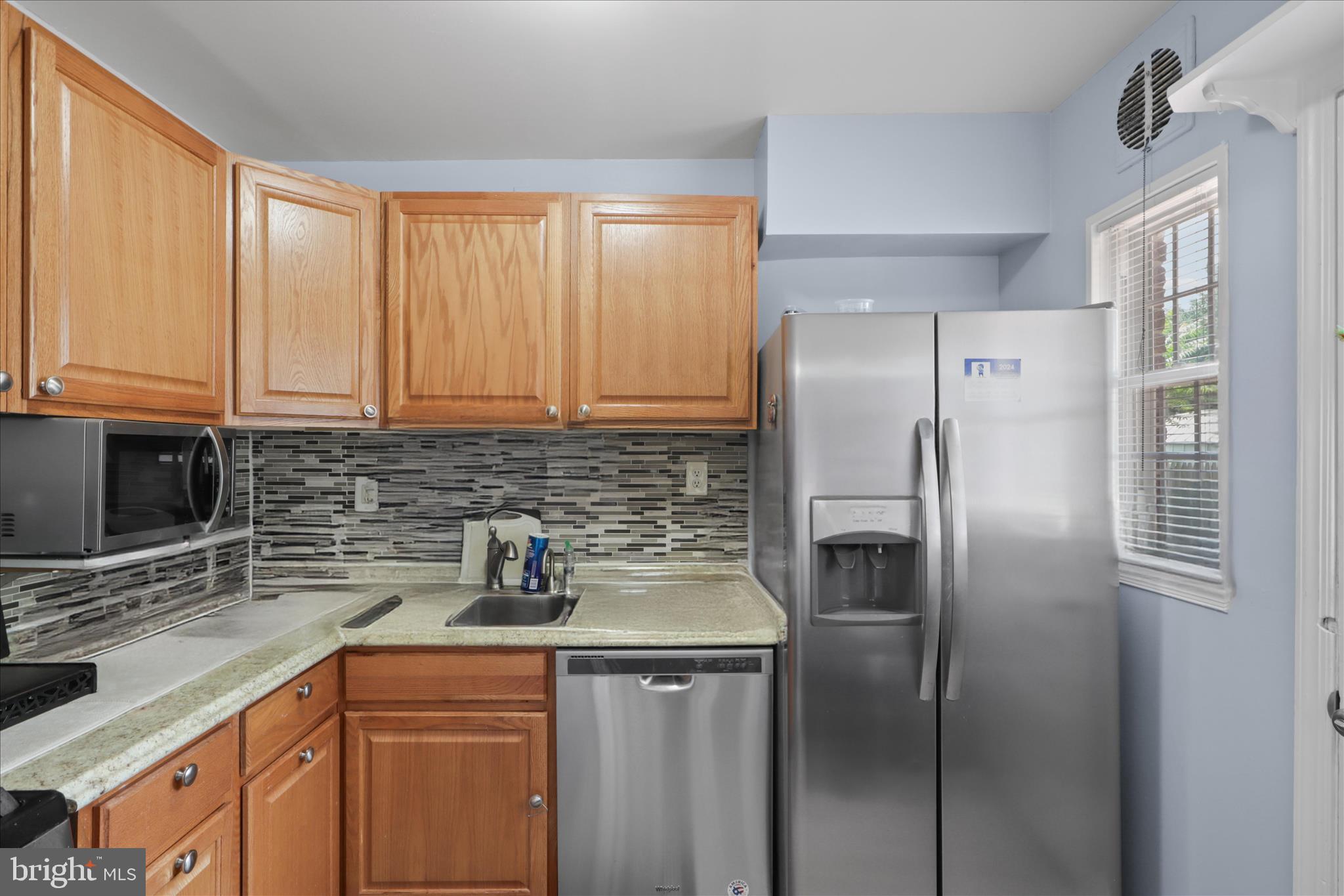 10602 Edgewood Avenue Silver Spring, MD 20901 - Photo 15 of 66 a kitchen with stainless steel appliances granite countertop a refrigerator a sink and white cabinets