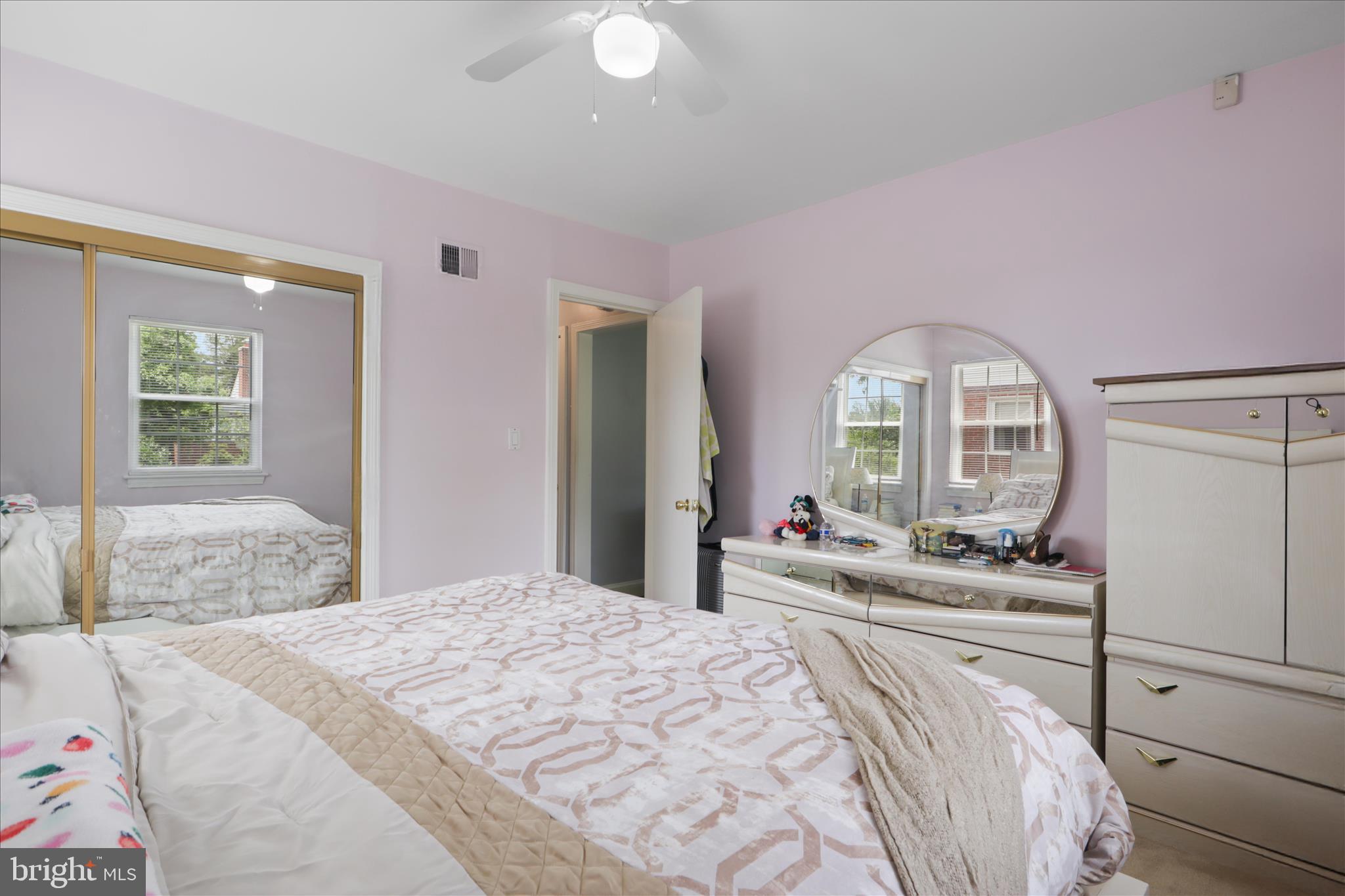 10602 Edgewood Avenue Silver Spring, MD 20901 - Photo 19 of 66 a bedroom with a bed and a large mirror on dresser next to a large window