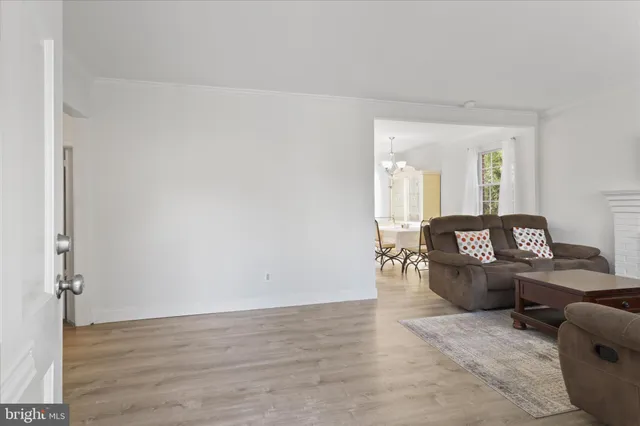 a dining room with wooden floor a chandelier a glass table and chairs