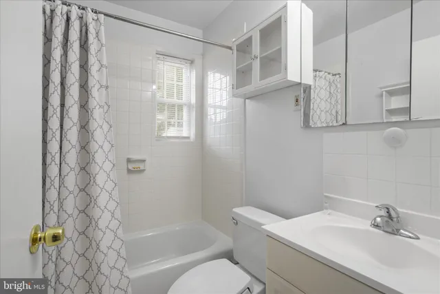 an empty room with a ceiling fan and window
