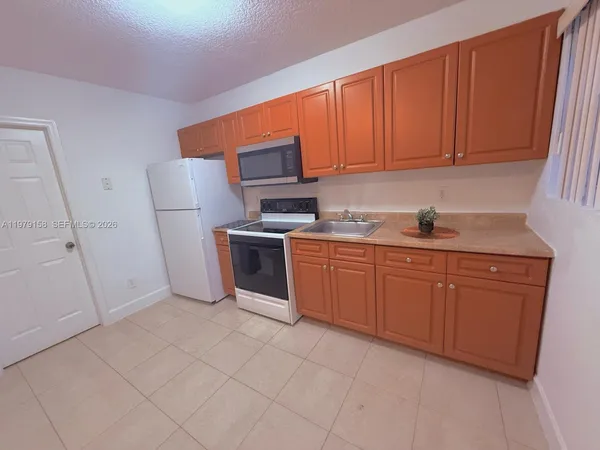 a kitchen with stainless steel appliances granite countertop a sink refrigerator and cabinets