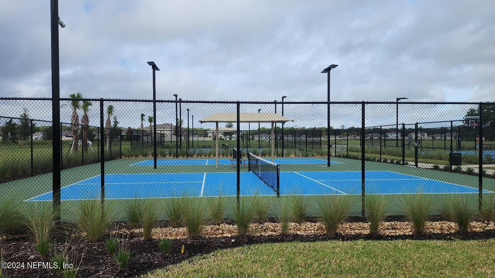 289 Narvarez Circle St. Augustine, FL 32084 - Photo 23 of 25 a view of a tennis court with a palm tree
