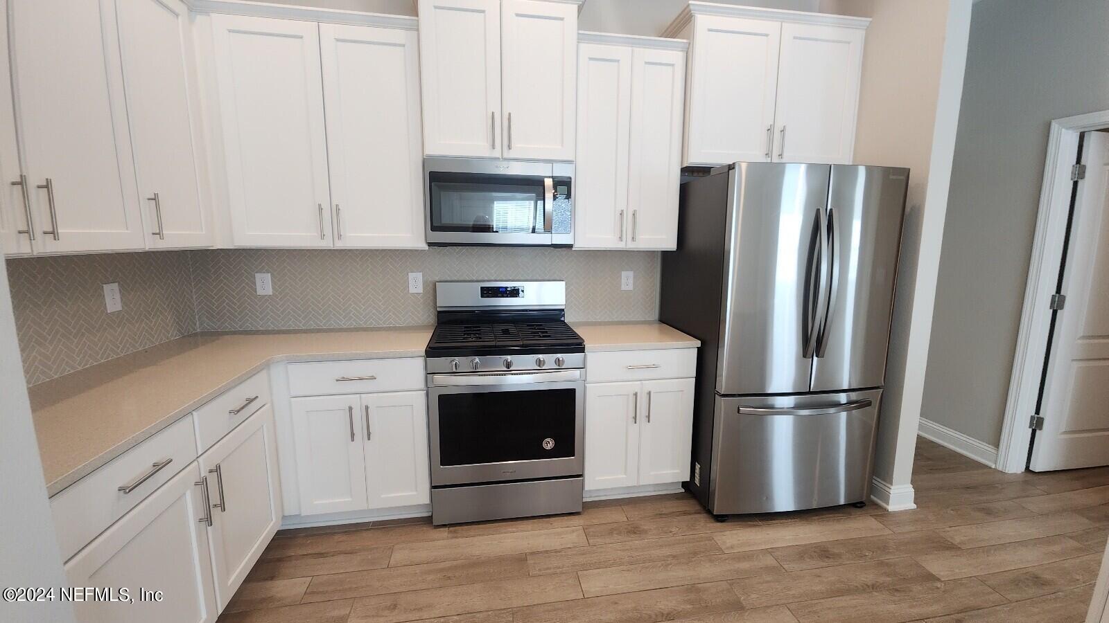 289 Narvarez Circle St. Augustine, FL 32084 - Photo 7 of 25 a kitchen with stainless steel appliances granite countertop a refrigerator sink and white cabinets