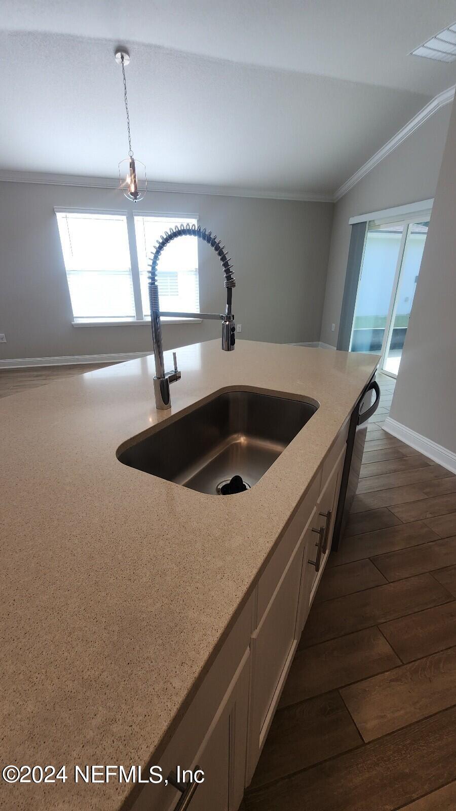 289 Narvarez Circle St. Augustine, FL 32084 - Photo 8 of 25 a view of kitchen island with a sink a window and wooden floor