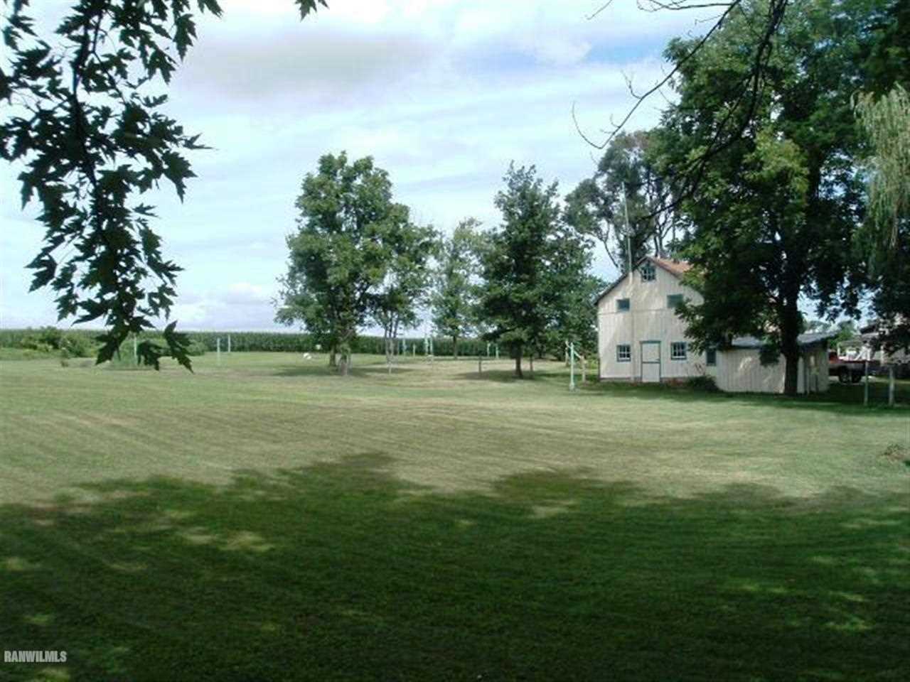 3360 South Rock City Road Ridott, IL 61067 - Photo 9 of 10 a view of a white house with a big yard and large trees