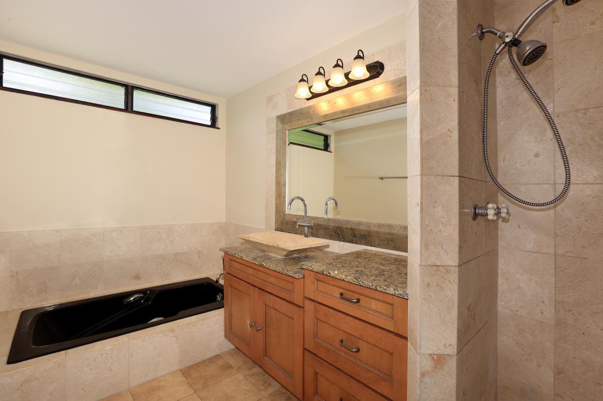 5045 Lower Honoapiilani Road, Unit 6 Lahaina, HI 96761 - Photo 24 of 30 a bathroom with a granite countertop sink a mirror and a shower