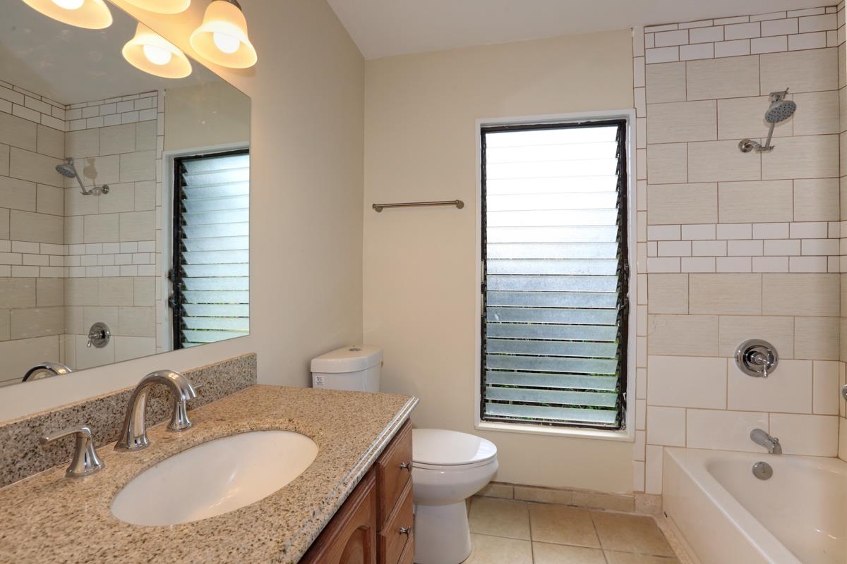 5045 Lower Honoapiilani Road, Unit 6 Lahaina, HI 96761 - Photo 26 of 30 a bathroom with a granite countertop sink toilet and shower