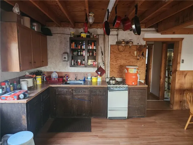 a kitchen with a wooden floor and cabinets