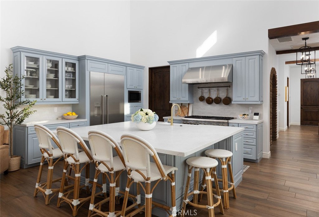 33240 La Serena Way Temecula, CA 92591 - Photo 16 of 75 a kitchen with stainless steel appliances a dining table chairs and refrigerator