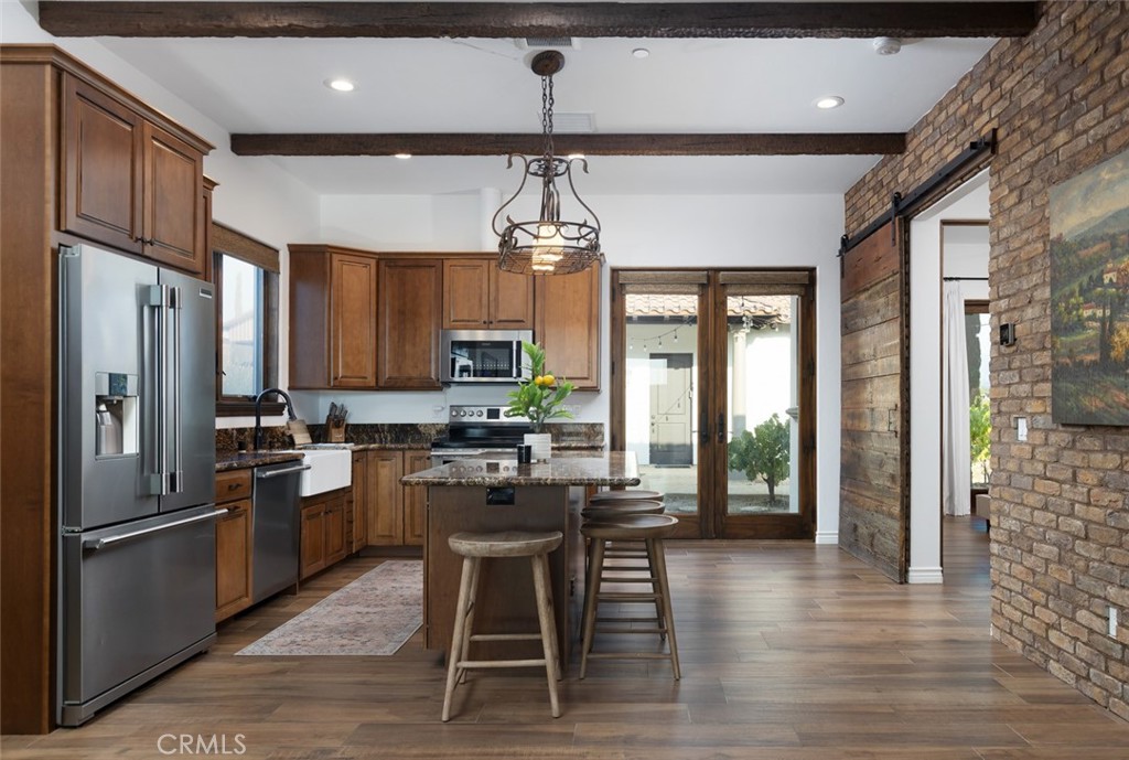 33240 La Serena Way Temecula, CA 92591 - Photo 40 of 75 a kitchen with stainless steel appliances a dining table chairs stove refrigerator and cabinets