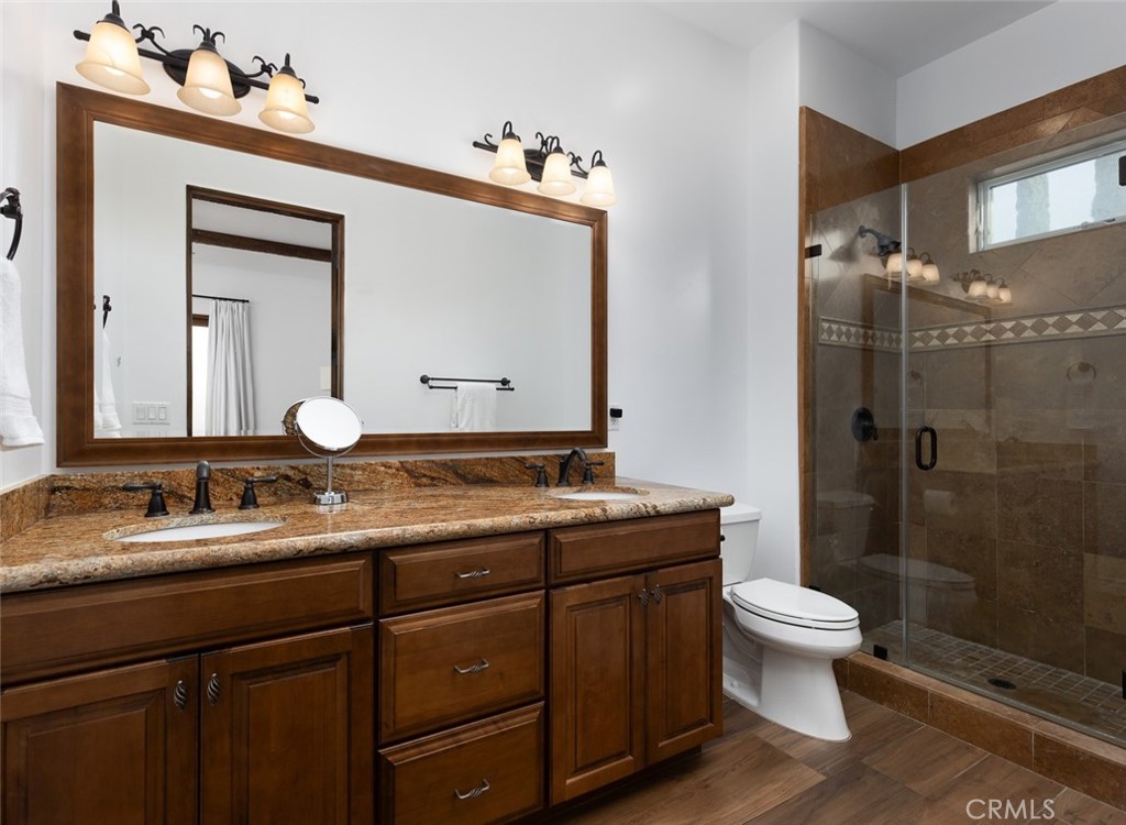 33240 La Serena Way Temecula, CA 92591 - Photo 44 of 75 a bathroom with a granite countertop sink toilet a mirror and shower