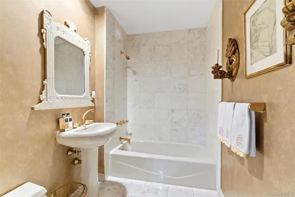 a bathroom with a sink a mirror toilet and bathtub