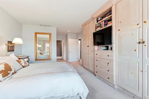 a bedroom with a bed and a flat tv screen in it