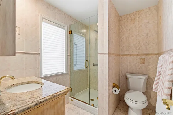 a bathroom with a granite countertop sink toilet and shower