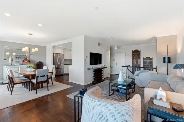 a living room with furniture a flat screen tv and kitchen view
