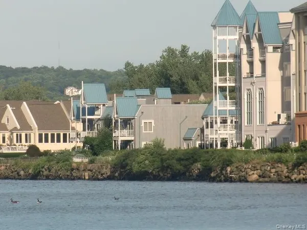an aerial view of ocean and residential houses with outdoor space