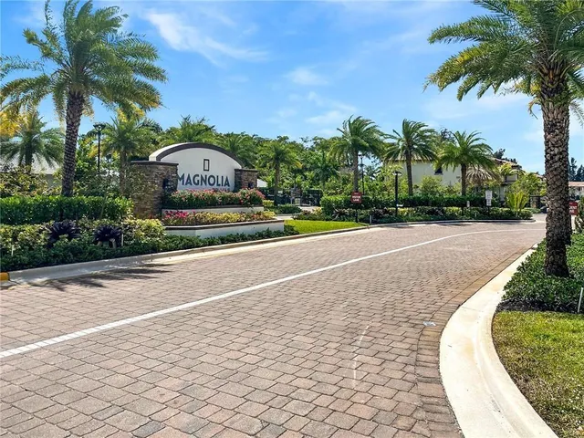 a front view of a house with a yard and palm trees