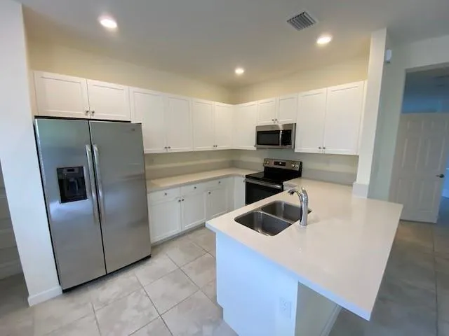 a kitchen with a sink a refrigerator and microwave