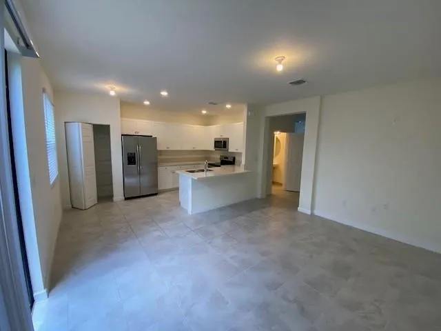 a view of a kitchen with a refrigerator a stove and a kitchen space