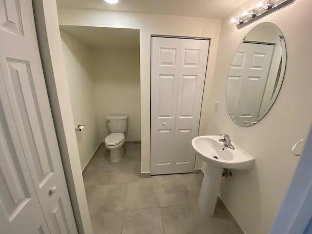 a bathroom with a sink a toilet and a mirror