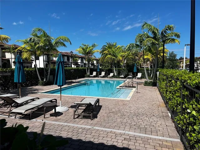 a view of a swimming pool with a patio and a yard