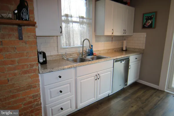 a kitchen with granite countertop white cabinets and sink