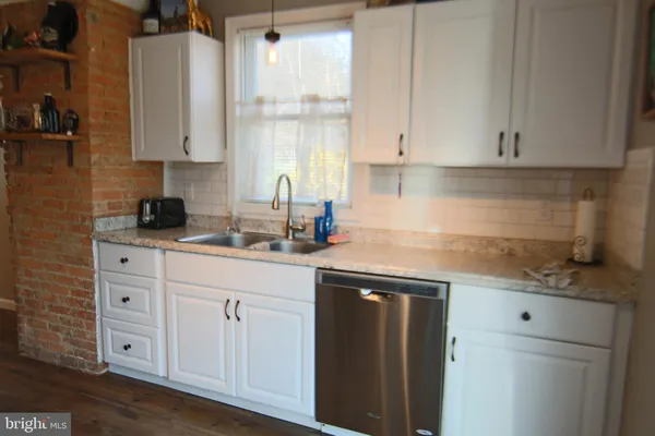 a kitchen with white cabinets and sink