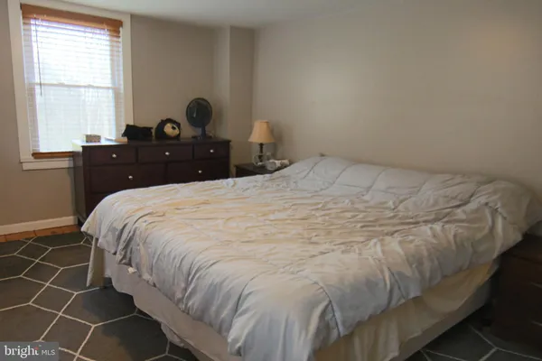 a large bed sitting in a bedroom next to a window and a desk