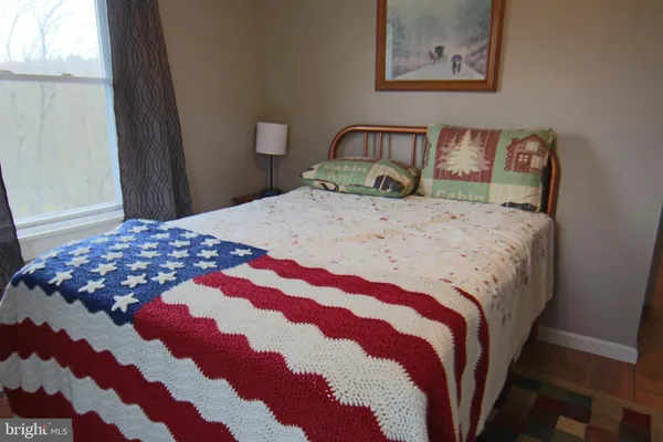a bedroom with a bed and painting on the wall