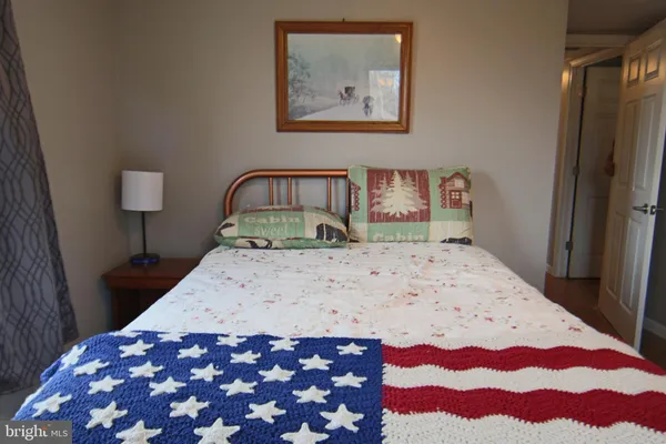 a bedroom with a bed and a lamp on dresser