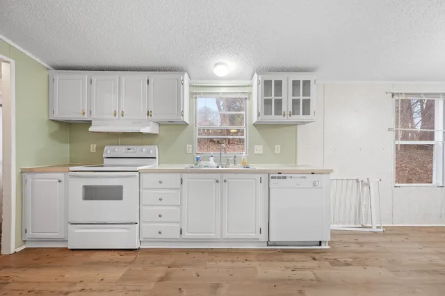 a kitchen with granite countertop white cabinets and stainless steel appliances