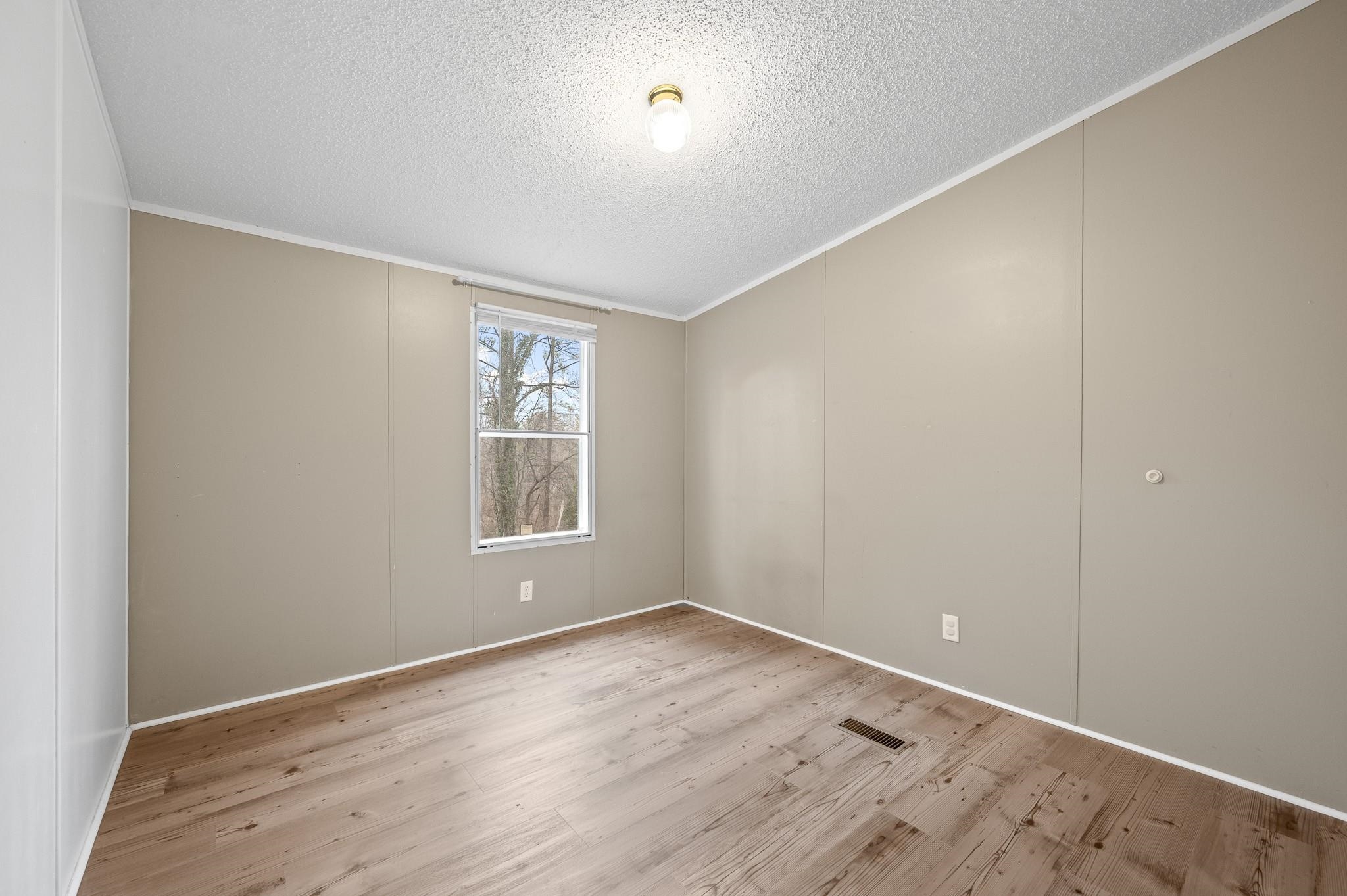 140 Garford Road Madison Heights, VA 24572 - Photo 18 of 32 an empty room with wooden floor and windows