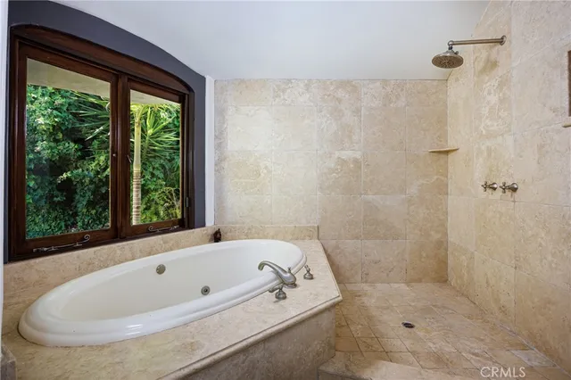 a white bath tub sitting in a bathroom next to a window