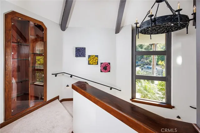 a hallway with a large window and chandelier