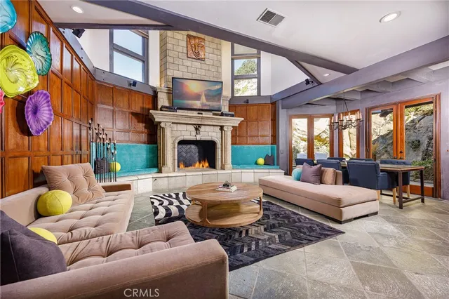 a living room with furniture a fireplace and a large window