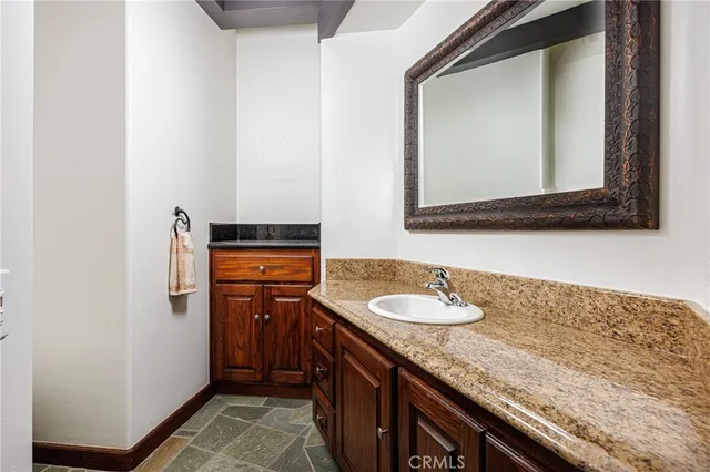 a bathroom with a granite countertop sink and a mirror