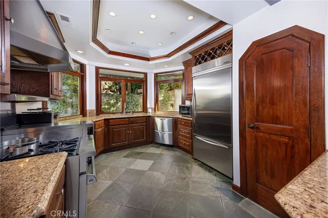 a kitchen with stainless steel appliances granite countertop a refrigerator and a stove