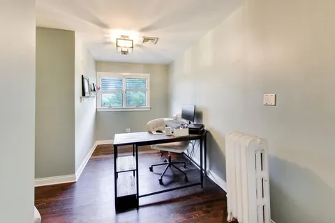 a view of a hallway with workspace and wooden floor