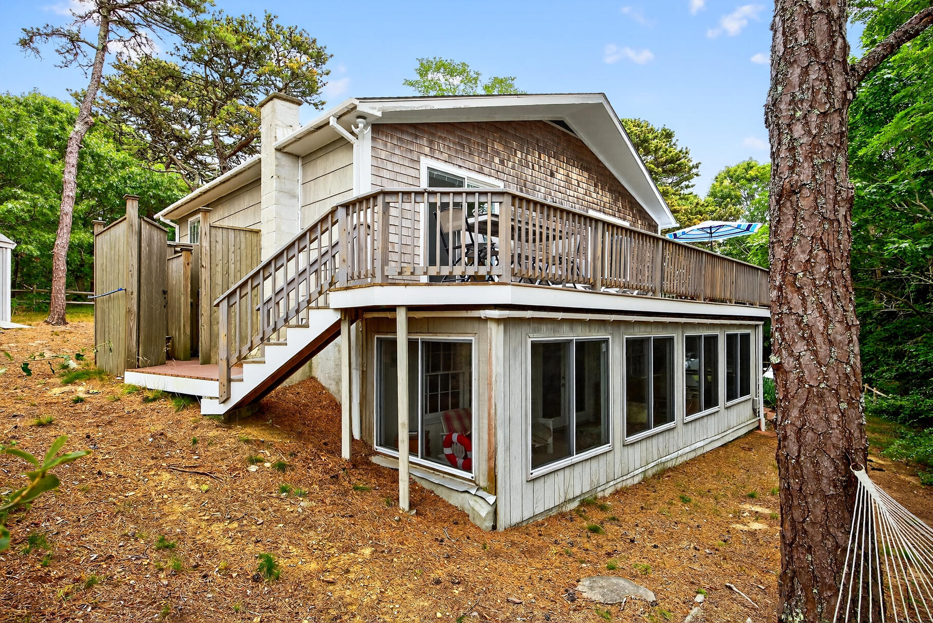 46 Hiram Hill Road Wellfleet, MA 02667 - Photo 36 of 36 a view of a white house with large windows and wooden fence