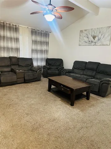 a living room with furniture and a lamp