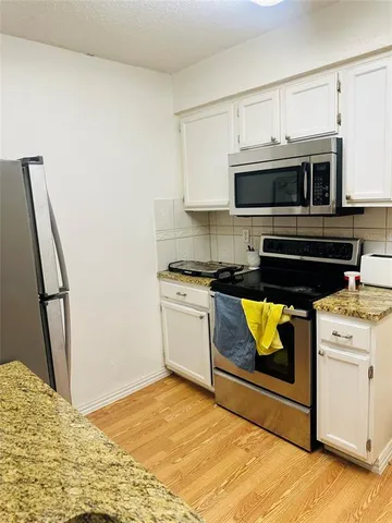 a kitchen with stainless steel appliances granite countertop a stove and a microwave