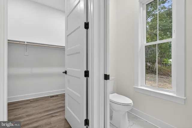 a view of a room with wooden floor air conditioner and windows