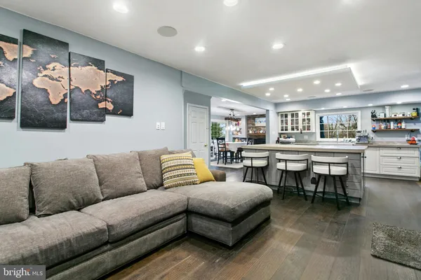 a living room with furniture and view of kitchen